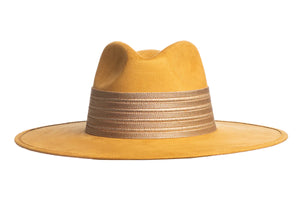 The Isabella hat is stiffened and shaped into a clean and ridged design, swathed in a premium mustard vegan suede. The rancher hat is finished with a thick gold elastic trim.