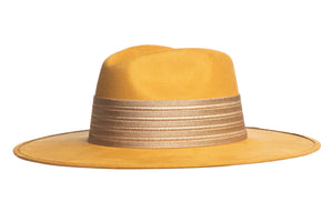 The Isabella hat is stiffened and shaped into a clean and ridged design, swathed in a premium mustard vegan suede. The rancher hat is finished with a thick gold elastic trim.