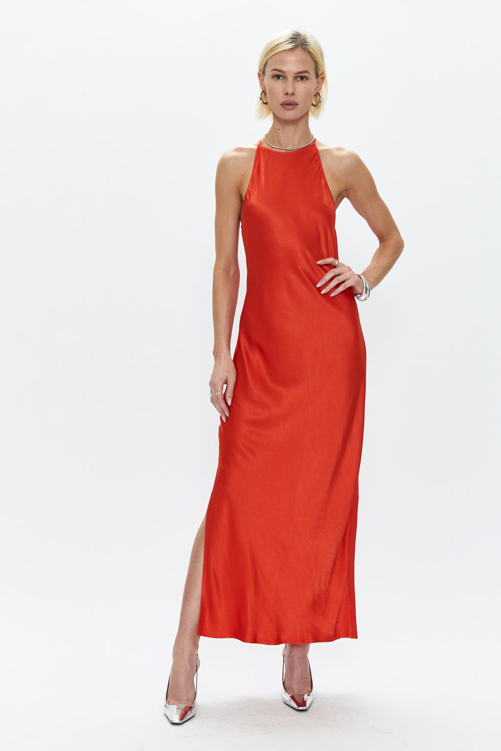 The type of effortless sophistication we've all been looking for. This high neck slip dress is created in a jaw dropping poppy red color, and has the interest factor of adjustable criss cross straps along the upper back. It also features a silky shine and a right leg side slit that begins right above the knee for easy movement.