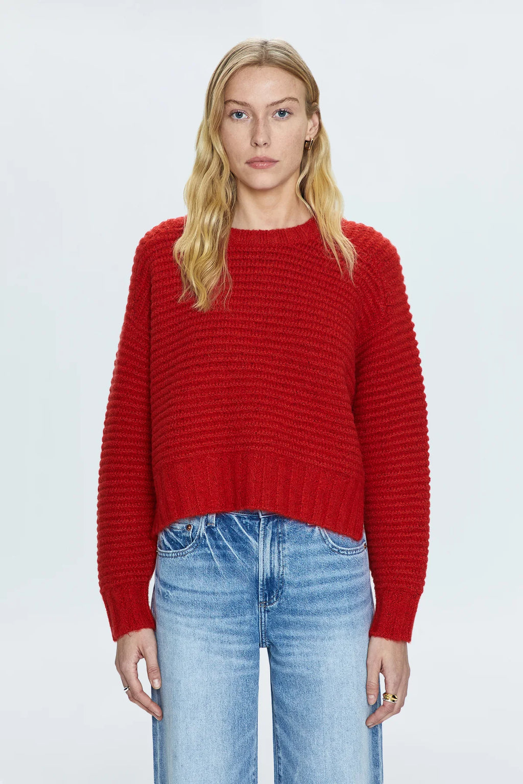 Medium weight, waffle knit sweater. Raglan, long sleeves with monochromatic rib trim at neckline, sleeves, and hem. Designed with an elongated crop proportion and split hem that grazes the waist. Rouge is a bright, cherry red for of-the-moment statement styling.