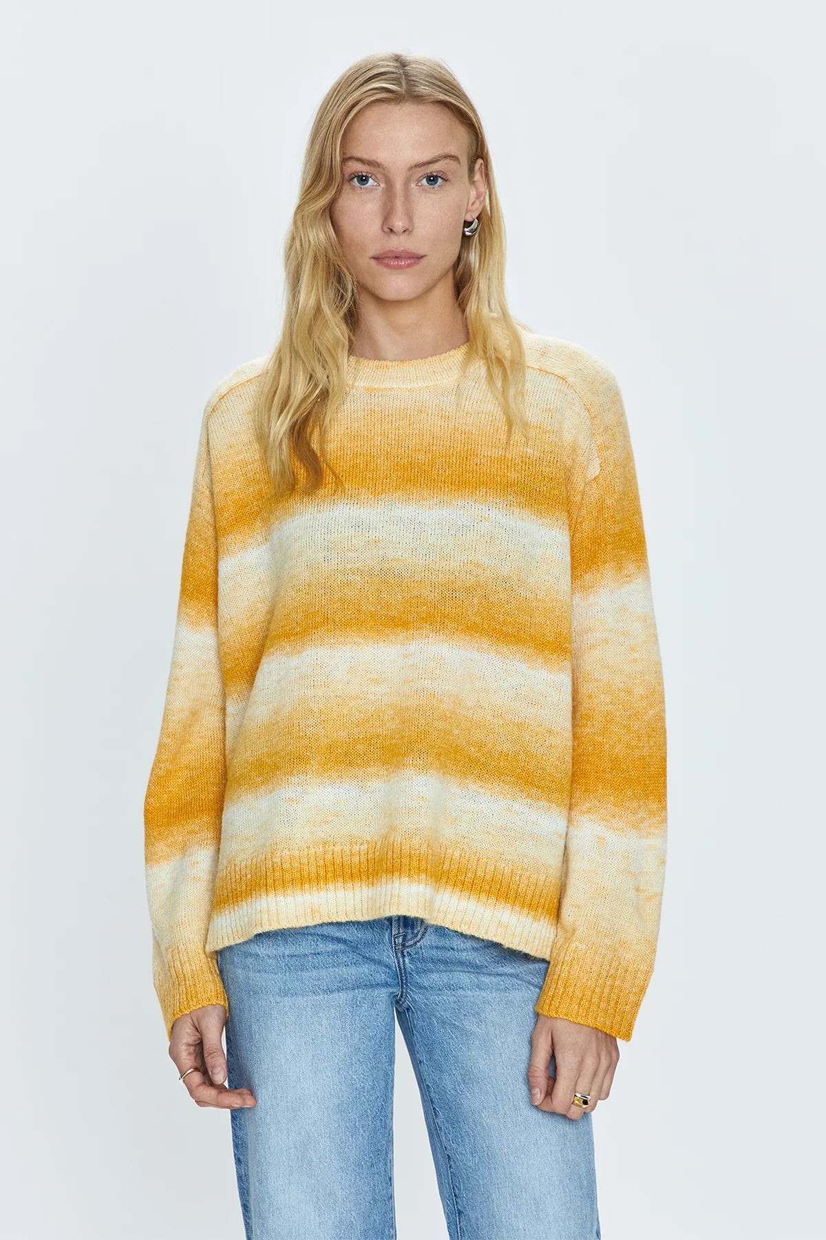 &nbsp;Lightweight transitional sweater crafted from a knit blend with a touch of wool. Crewneck silhouette with long sleeves, raglan shoulders, and a relaxed fit. Sunset is a dip-dye striped color effect featuring warm shades of ivory, yellow, and orange.&nbsp;