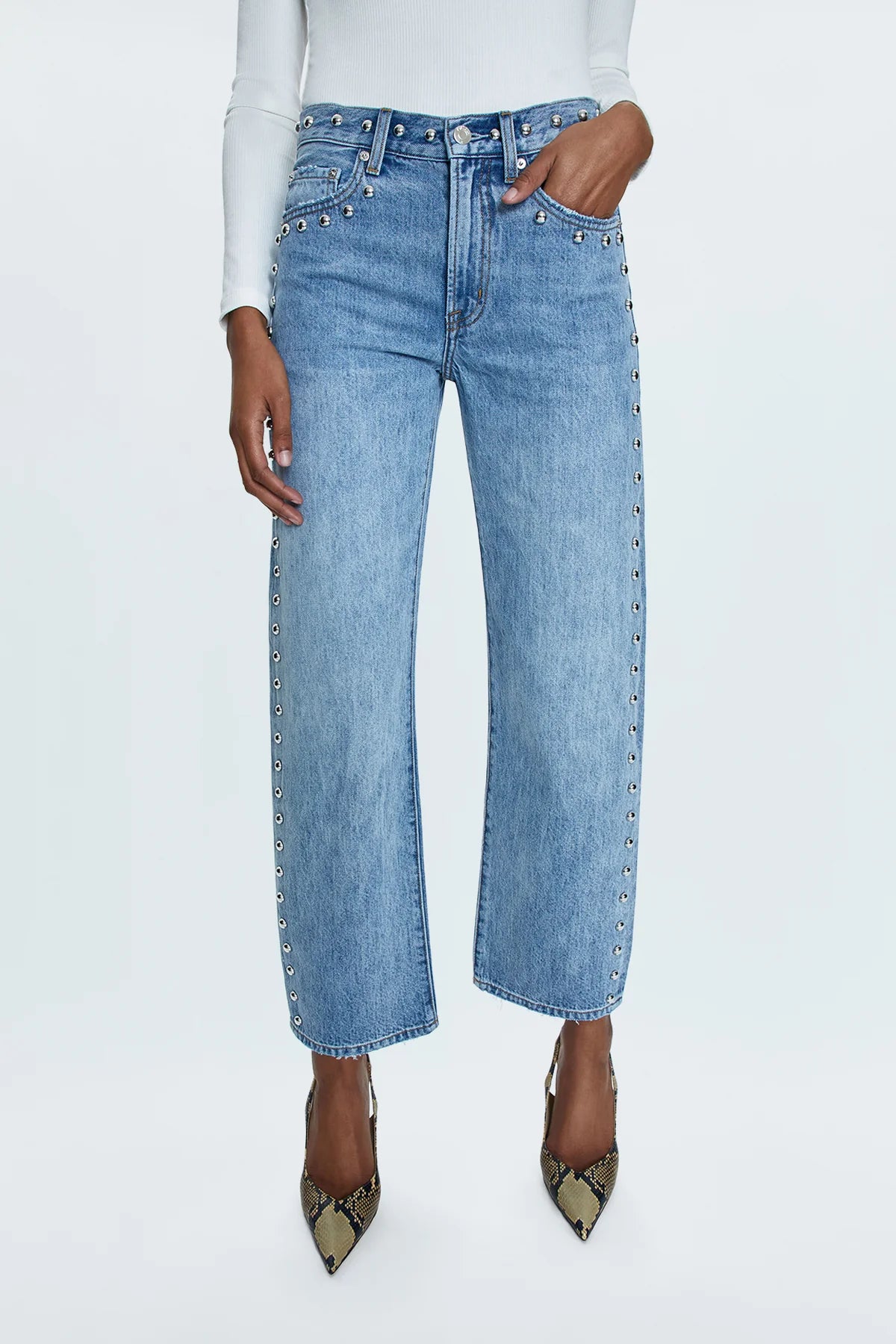 Mid-rise, with a straight leg that bows at the knees for an arched, barrel leg silhouette. Ankle length crop with a clean finish hem, crafted from rigid non-stretch denim for an expert fit that holds its shape. Satellite is a light blue denim wash with vintage fading, defined by linear stud decorations along both legs, waistband, and front pockets.