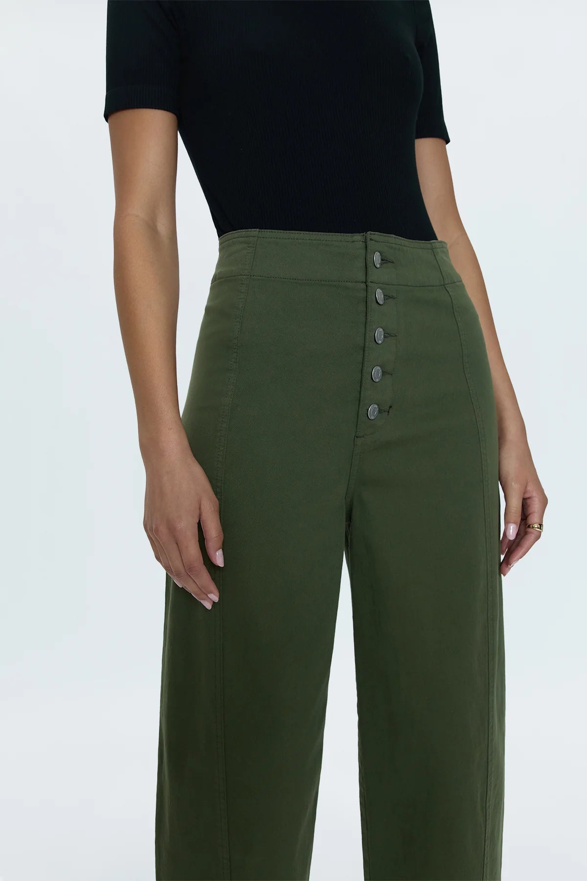 Reporting for duty. Super high waist trouser with a statement button up fly, free of front pockets for a slimming, structured fit. Double paneled legs crafted to fall into a relaxed, barrel leg silhouette that crops at the ankles. Admiral is an elevated, military green color way that doubles as a seasonal neutral for endless styling potential.