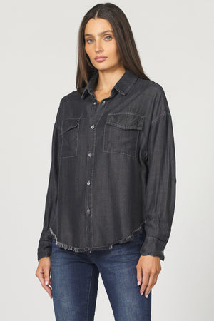Woman wearing a black denim shirt and blue jeans on a white background