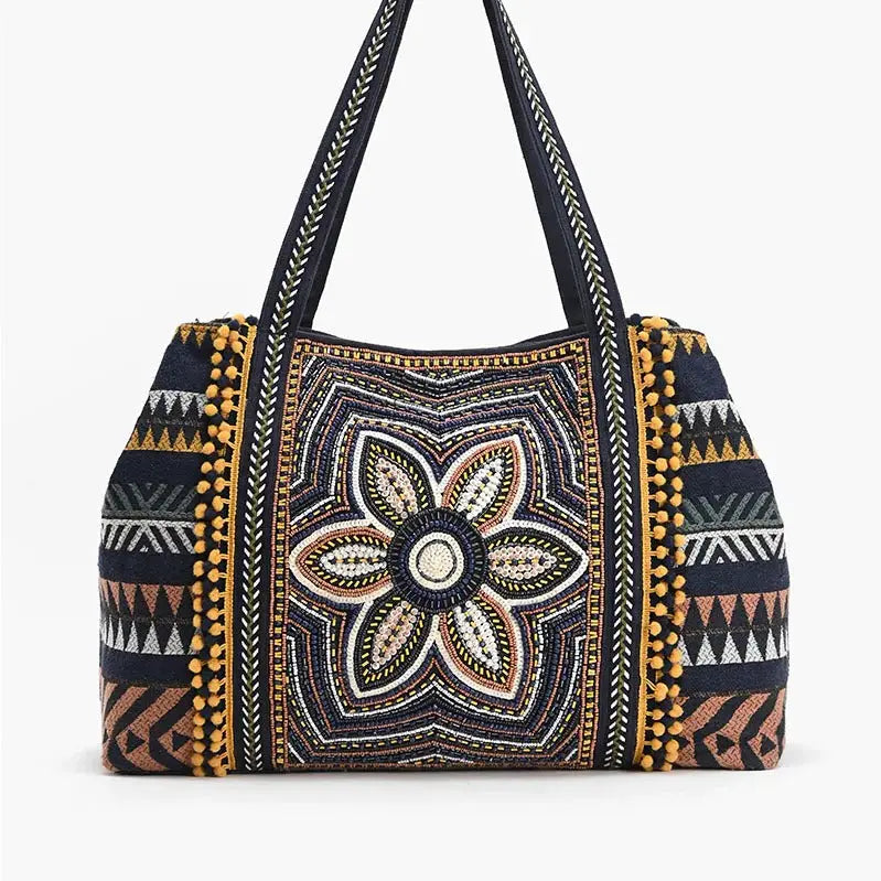 Embroidered handbag with floral design and geometric patterns on a white background