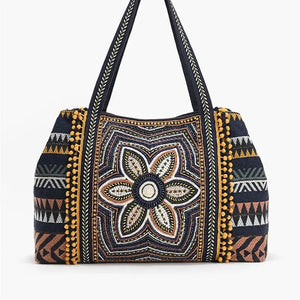 Embroidered handbag with floral design and geometric patterns on a white background
