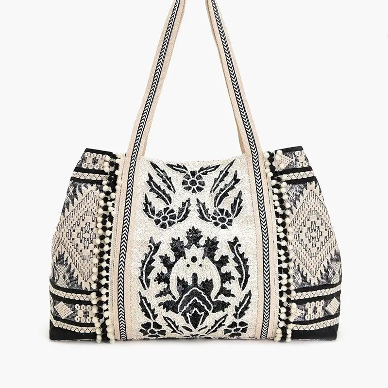 Embroidered handbag with black patterns on a white background