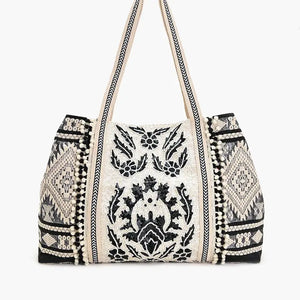 Embroidered handbag with black patterns on a white background