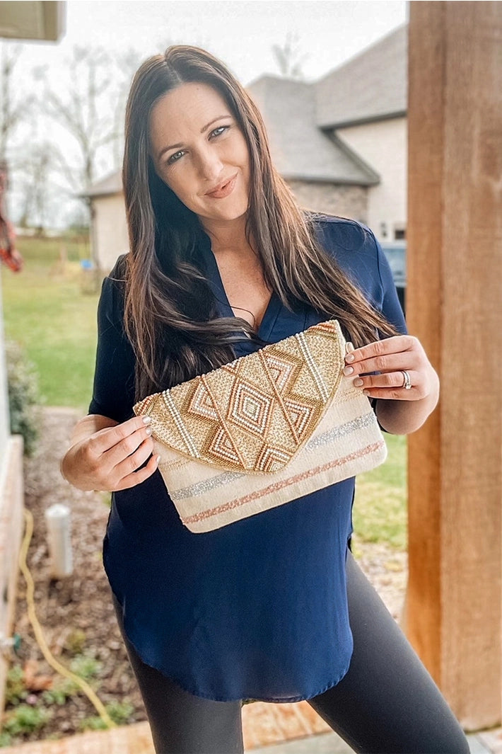Carry your essentials in style with this eye-catching flap clutch from America & Beyond! The hand-embellished beaded flap adds a pop of personality to any outfit. Switch between handheld elegance and hands-free convenience with the detachable chain strap.