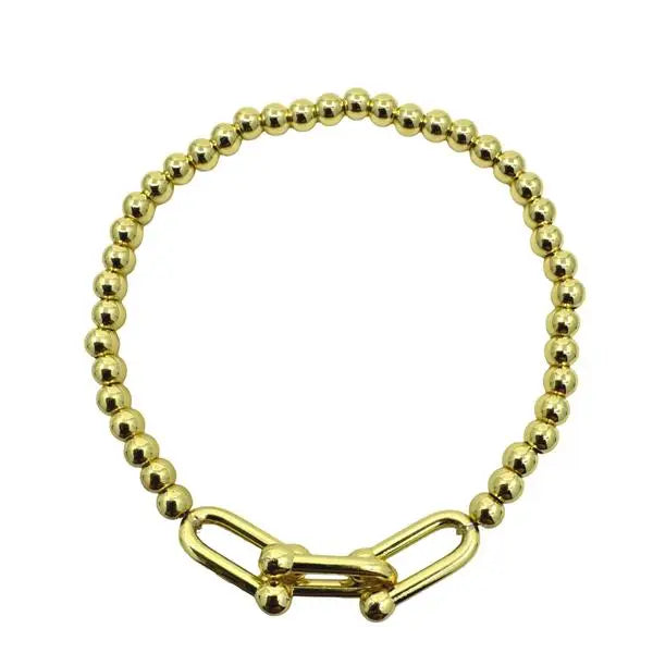 Gold beaded bracelet with a clasp on a white background