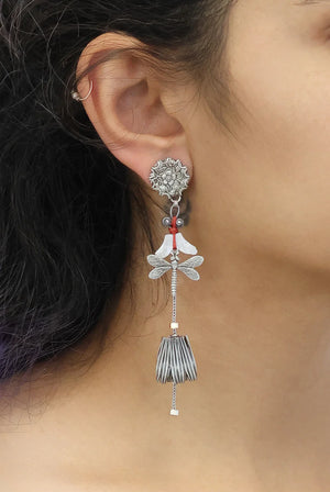 Close-up of an ear wearing a decorative earring with intricate design.