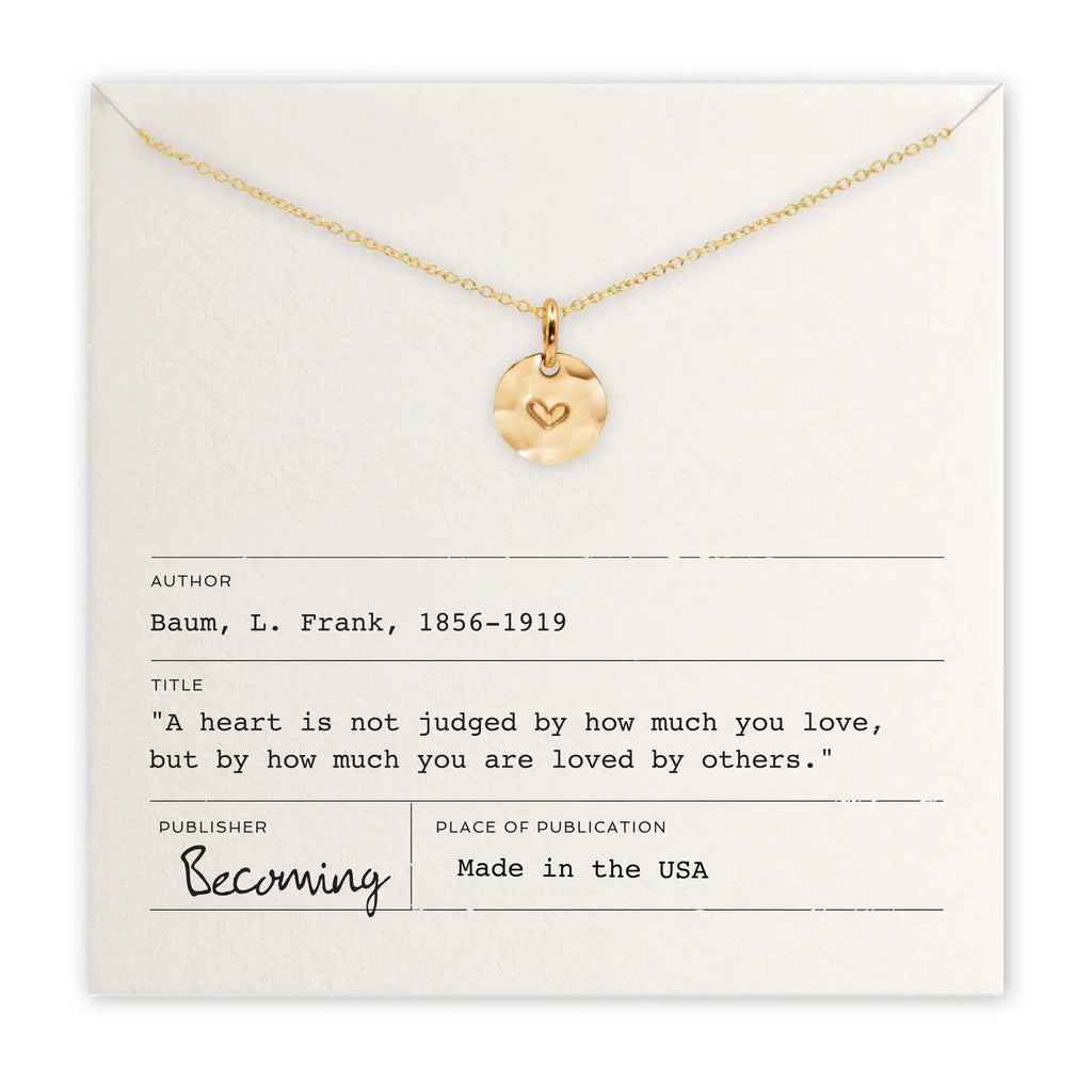 Gold necklace with a heart pendant on a card with text