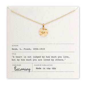 Gold necklace with a heart pendant on a card with text
