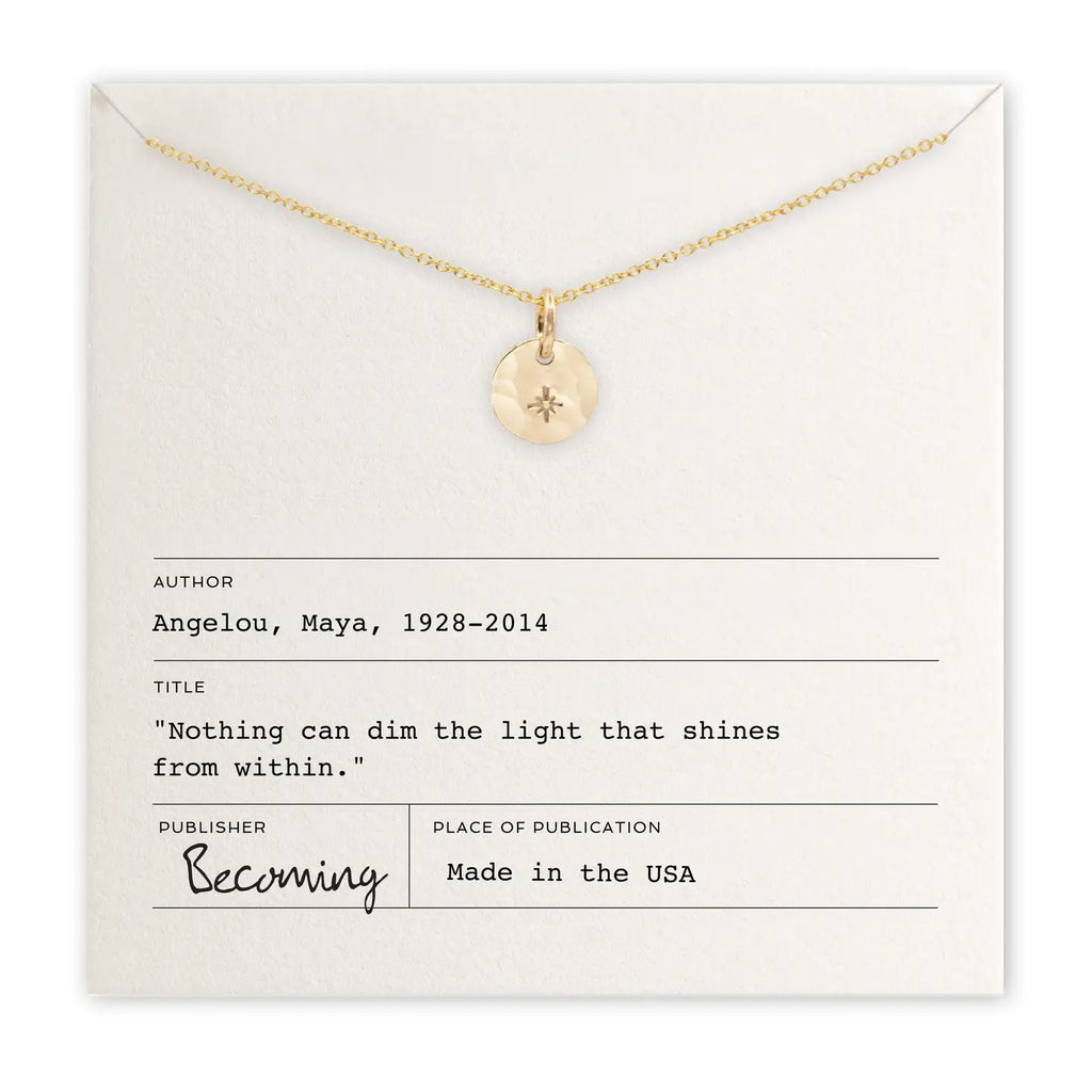 Gold necklace with a pendant on a card featuring text