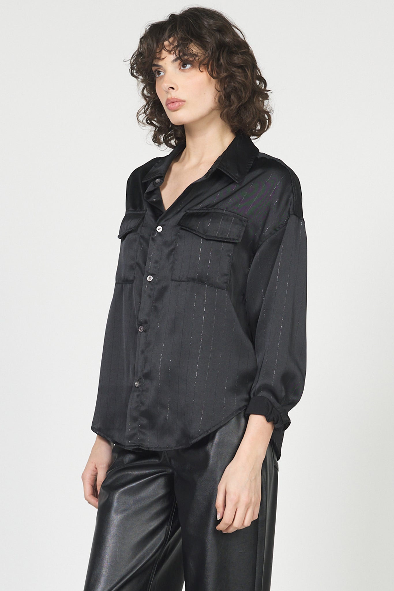 Woman wearing a black shirt and leather pants on a white background