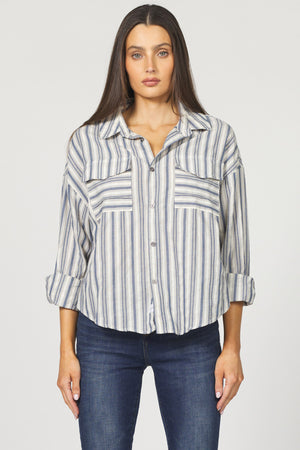 Woman wearing a striped shirt and jeans on a plain background