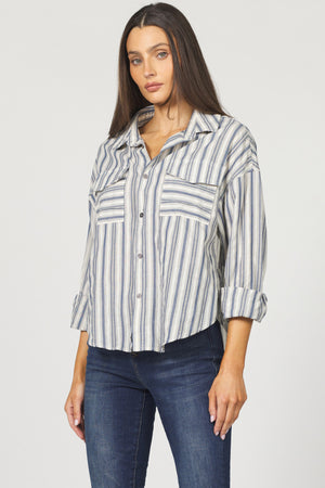 Woman wearing a striped shirt and jeans on a plain background