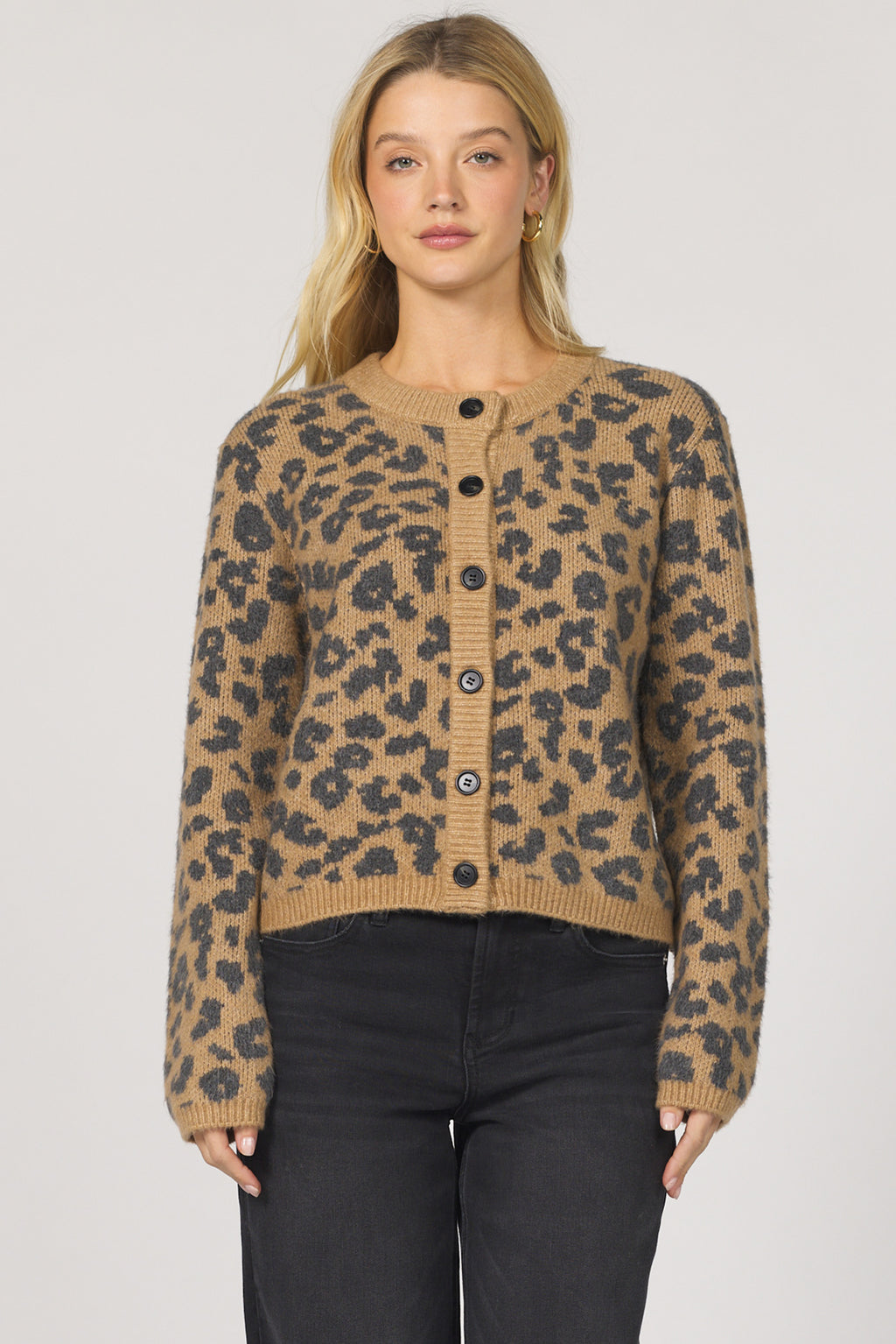 Woman wearing a leopard print cardigan on a plain background