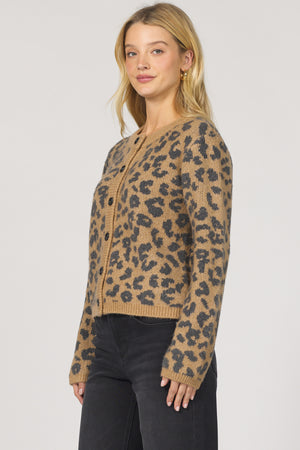 Woman wearing a leopard print sweater against a plain background