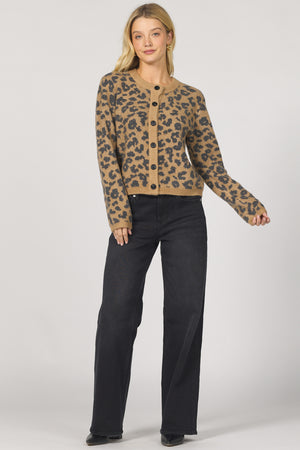 Woman wearing a leopard print jacket and black pants on a white background