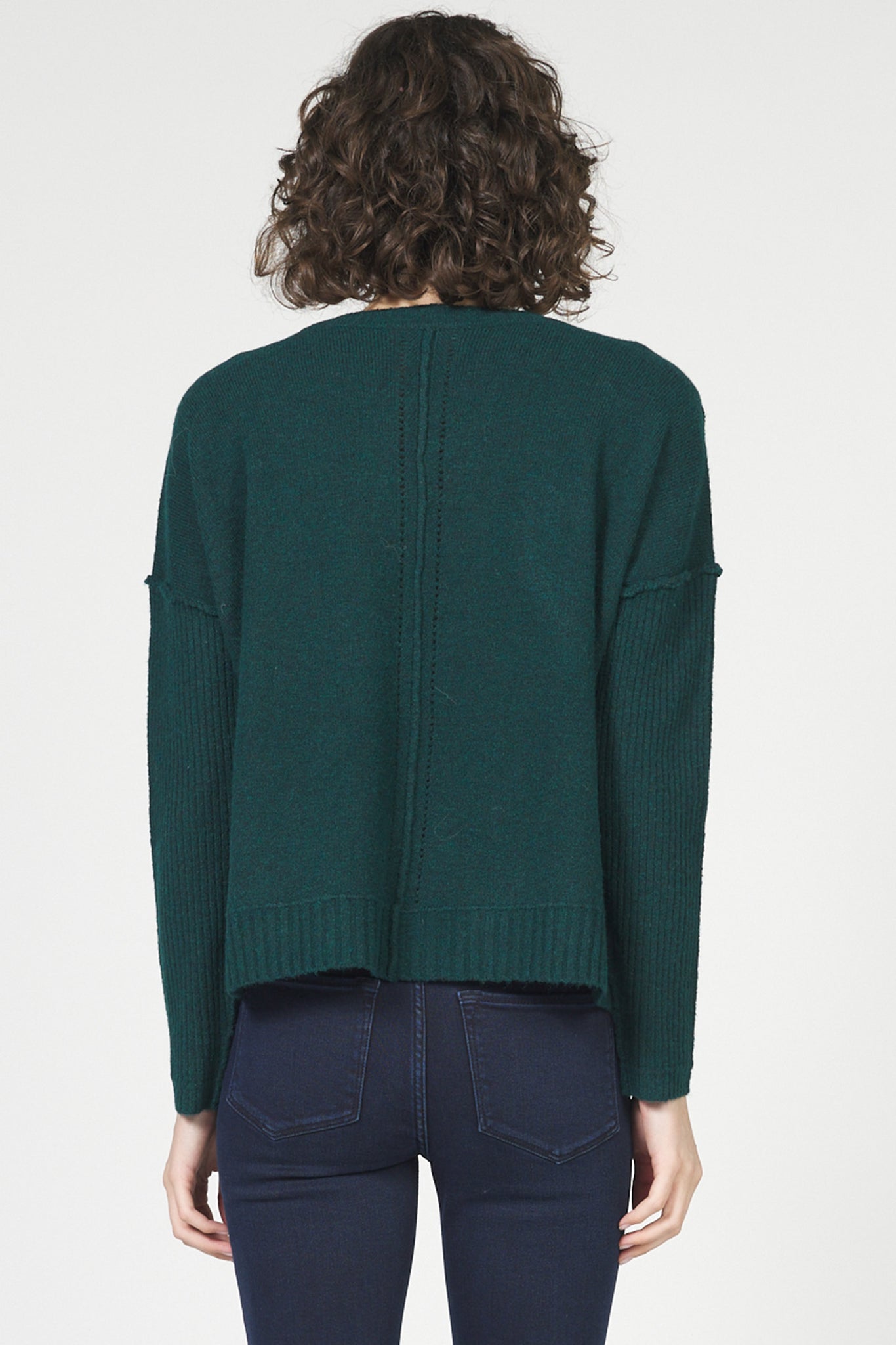 Person wearing a green sweater from behind on a white background