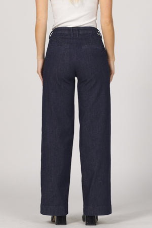 Navy blue pants worn by a person on a plain background