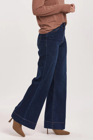 High rise wide leg jeans. It's cozy fit that sits at natural waist, embraces your natural curves and accentuates your hips and thigh. Full inseam on stretch denim accented with wide hem cuff, tailor pressed seam lines, cut-off hem details, washed in rich indigo shade.