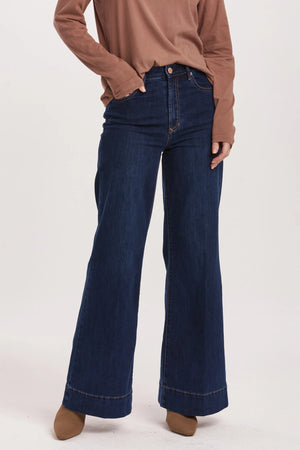 High rise wide leg jeans. It's cozy fit that sits at natural waist, embraces your natural curves and accentuates your hips and thigh. Full inseam on stretch denim accented with wide hem cuff, tailor pressed seam lines, cut-off hem details, washed in rich indigo shade.