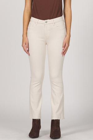 Person wearing white pants and brown shoes on a plain background