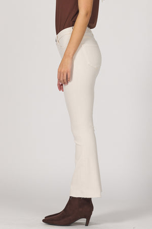 Person wearing white pants and brown shoes on a plain background