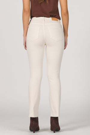 Person wearing white pants and brown shoes on a plain background