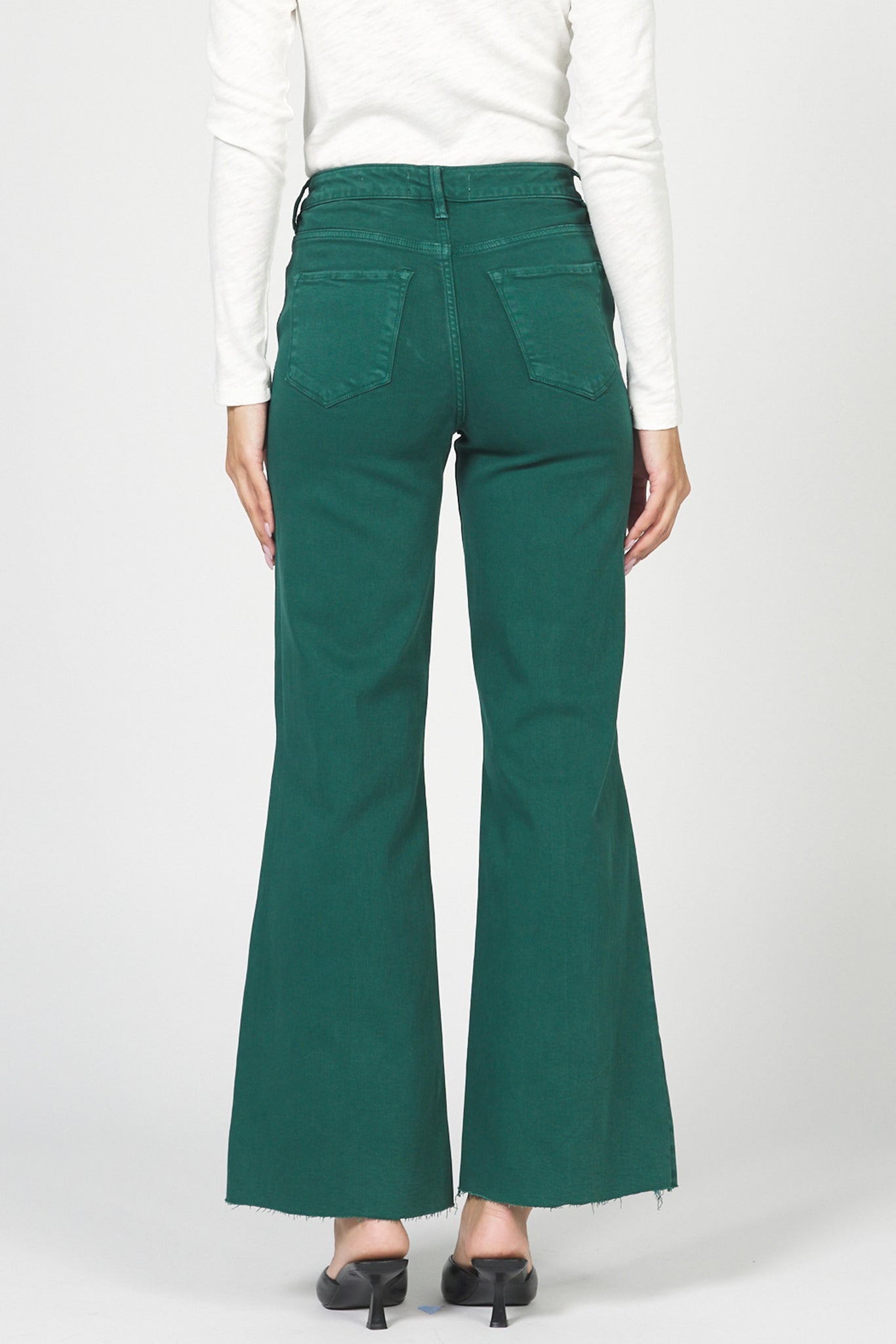 Green bell-bottom pants worn by a person on a white background