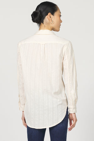 Woman wearing a white striped shirt on a plain background