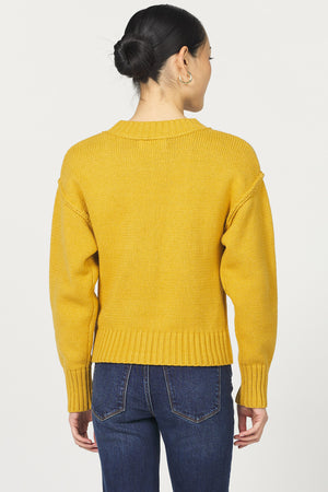 Person wearing a yellow sweater and blue jeans on a white background