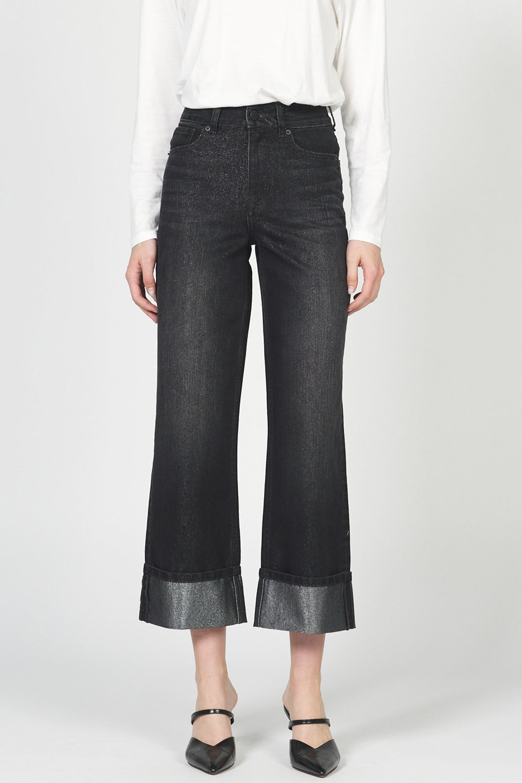 Person wearing black wide-leg jeans on a white background