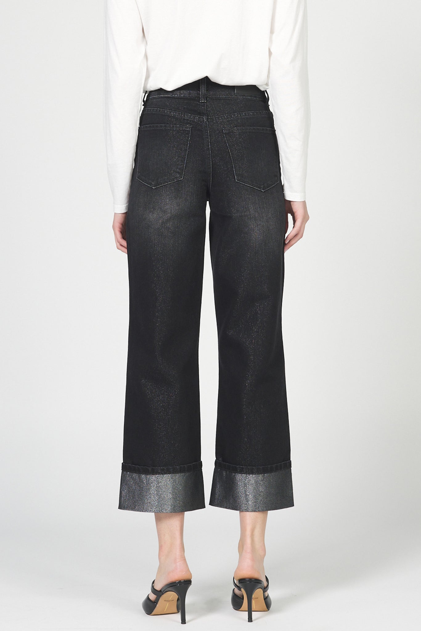 Black wide-leg jeans worn by a person on a white background