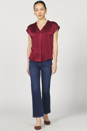 Woman wearing a red blouse and blue jeans on a white background