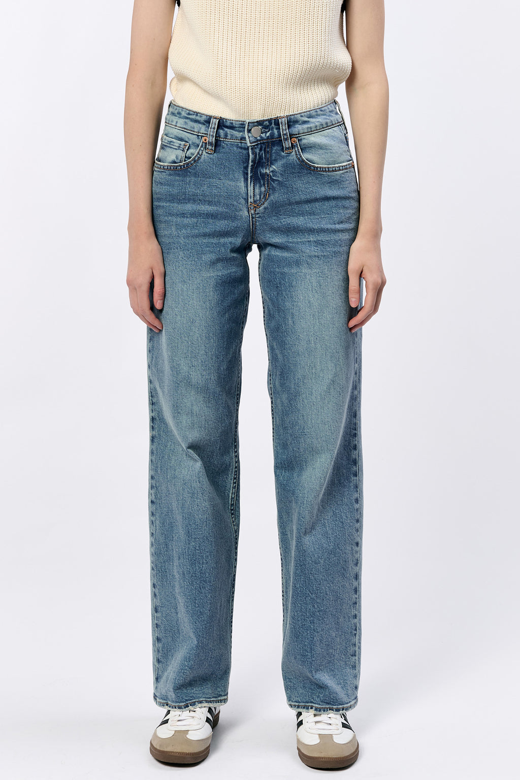 Person wearing blue jeans on a white background