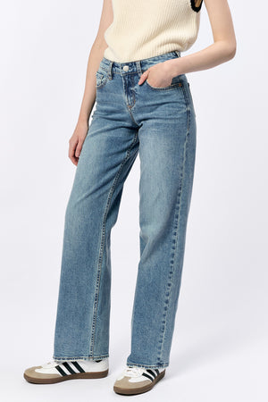 Person wearing light blue jeans on a white background