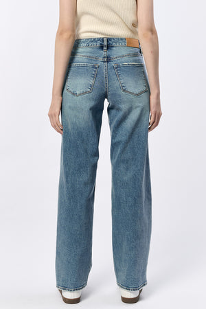 Person wearing blue jeans on a white background
