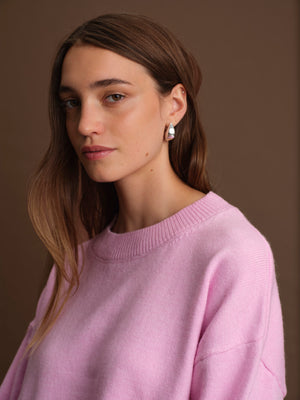 Woman wearing a light purple sweater against a brown background