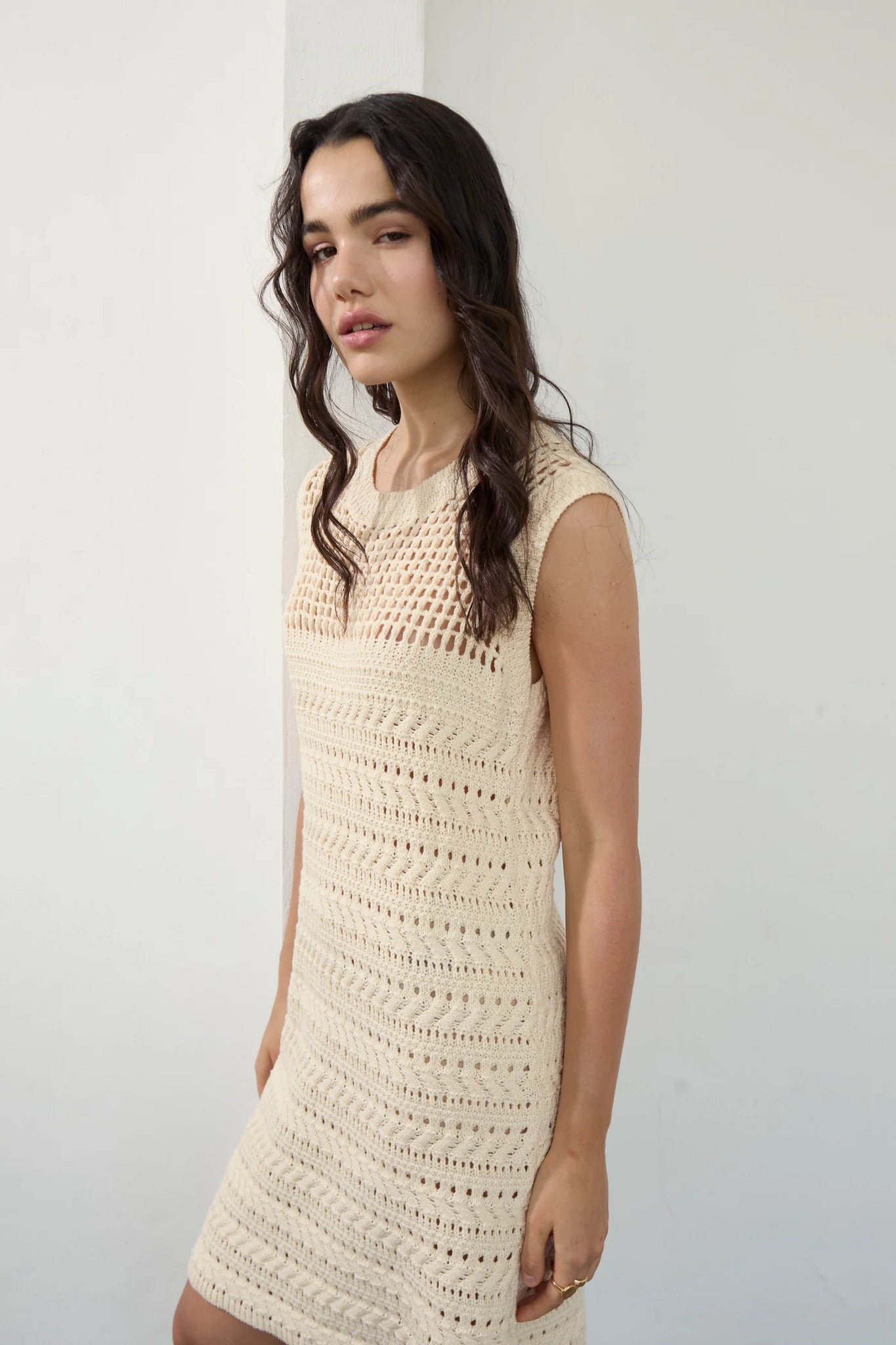Upgrade your wardrobe with the playful and versatile RUI Knit Dress from Deluc. Made with a soft cotton blend, this sleeveless midi dress features a round collar and a unique open work knit design. The detachable belt adds a touch of customization to this quirky and fun dress.