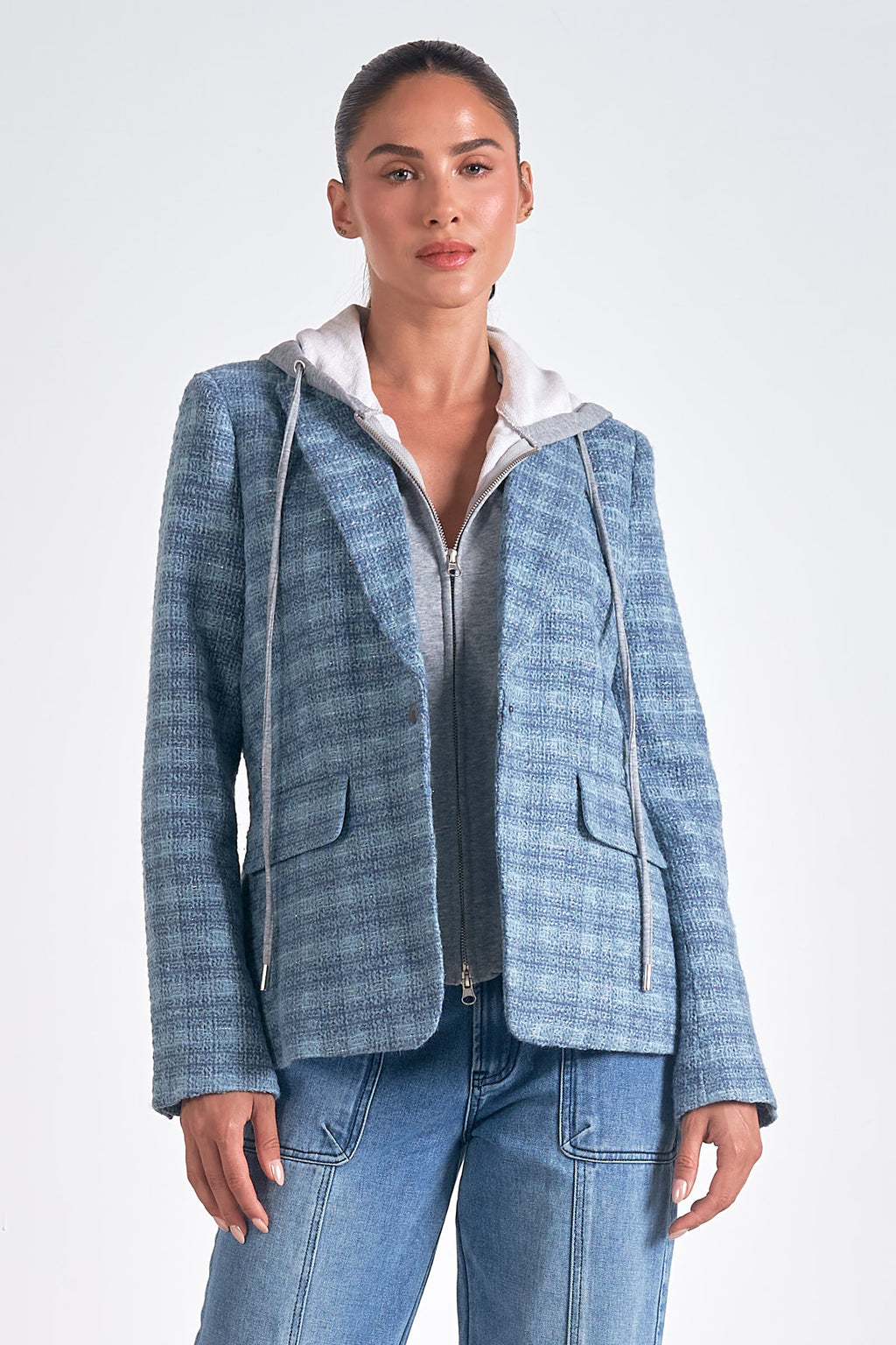 Introducing Elan's Manhattan blazer, the perfect blend of quirky and sleek! With a blue silver plaid design and a hidden hoodie, this blazer is both stylish and playful. Upgrade your wardrobe with this statement piece.