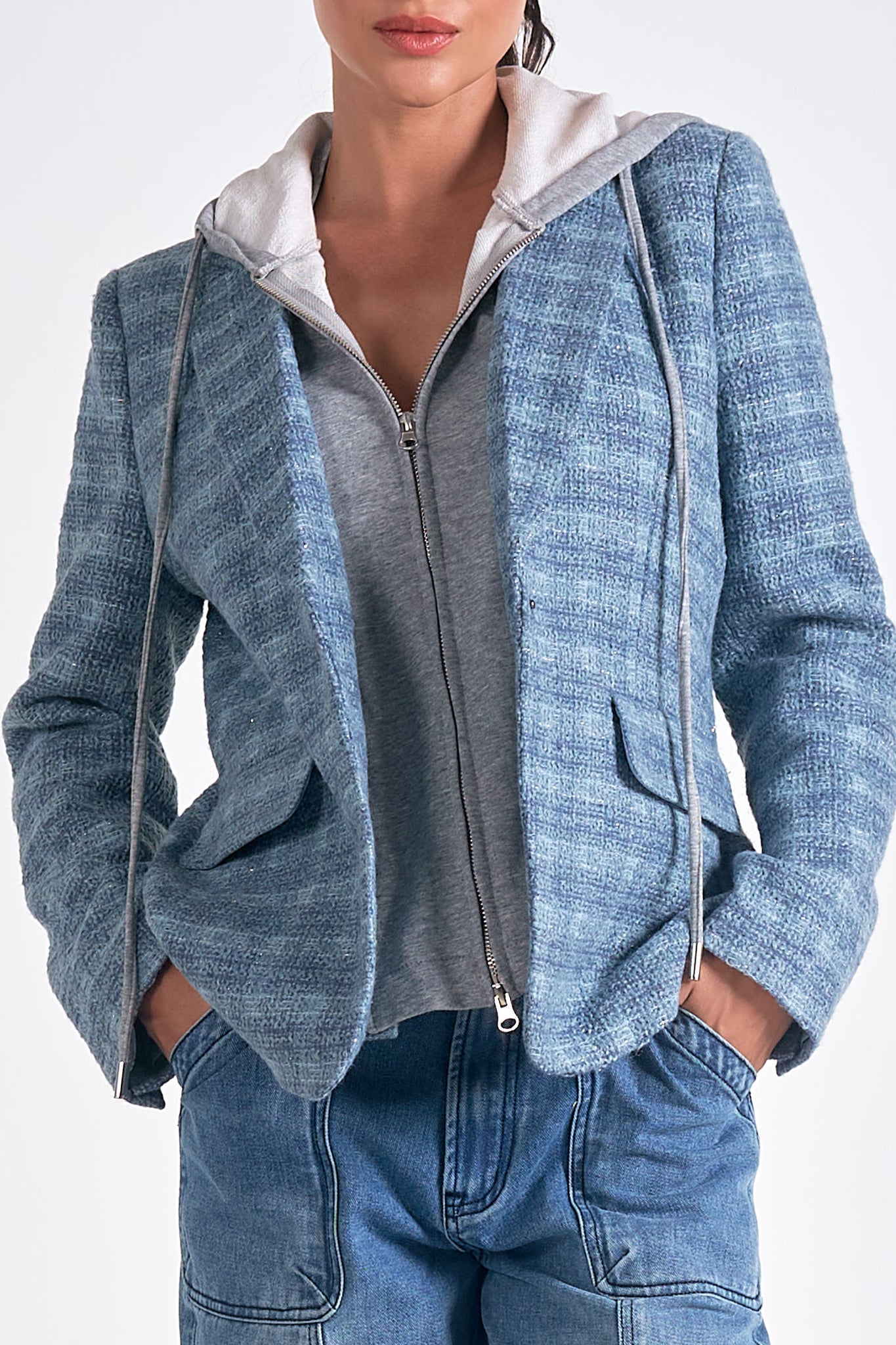 Introducing Elan's Manhattan blazer, the perfect blend of quirky and sleek! With a blue silver plaid design and a hidden hoodie, this blazer is both stylish and playful. Upgrade your wardrobe with this statement piece.