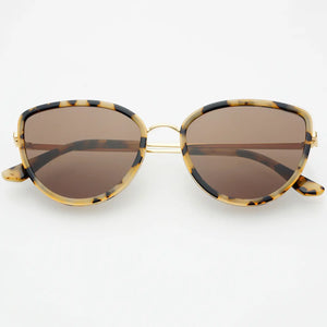 Sunglasses with gold frame and tortoiseshell accents on a white background