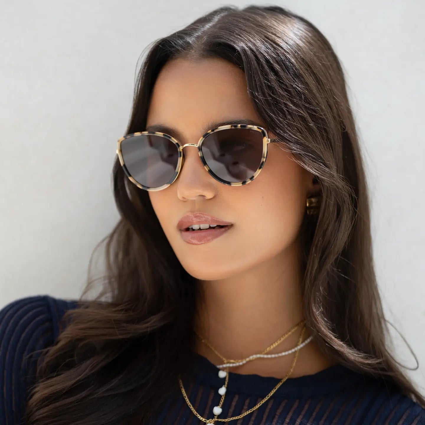 Woman wearing sunglasses with a neutral background