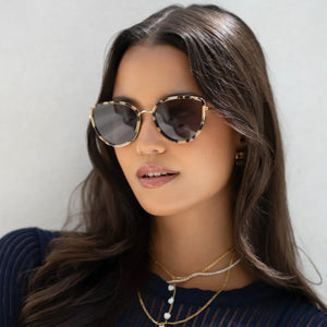 Woman wearing sunglasses with a neutral background