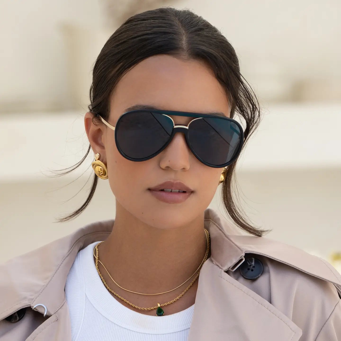 Woman wearing sunglasses with a neutral background