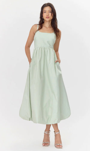 This midi dress is defined by it's bold and playful bubble skirt. The structure showcases hidden pockets, a smocked back, and a square neckline.