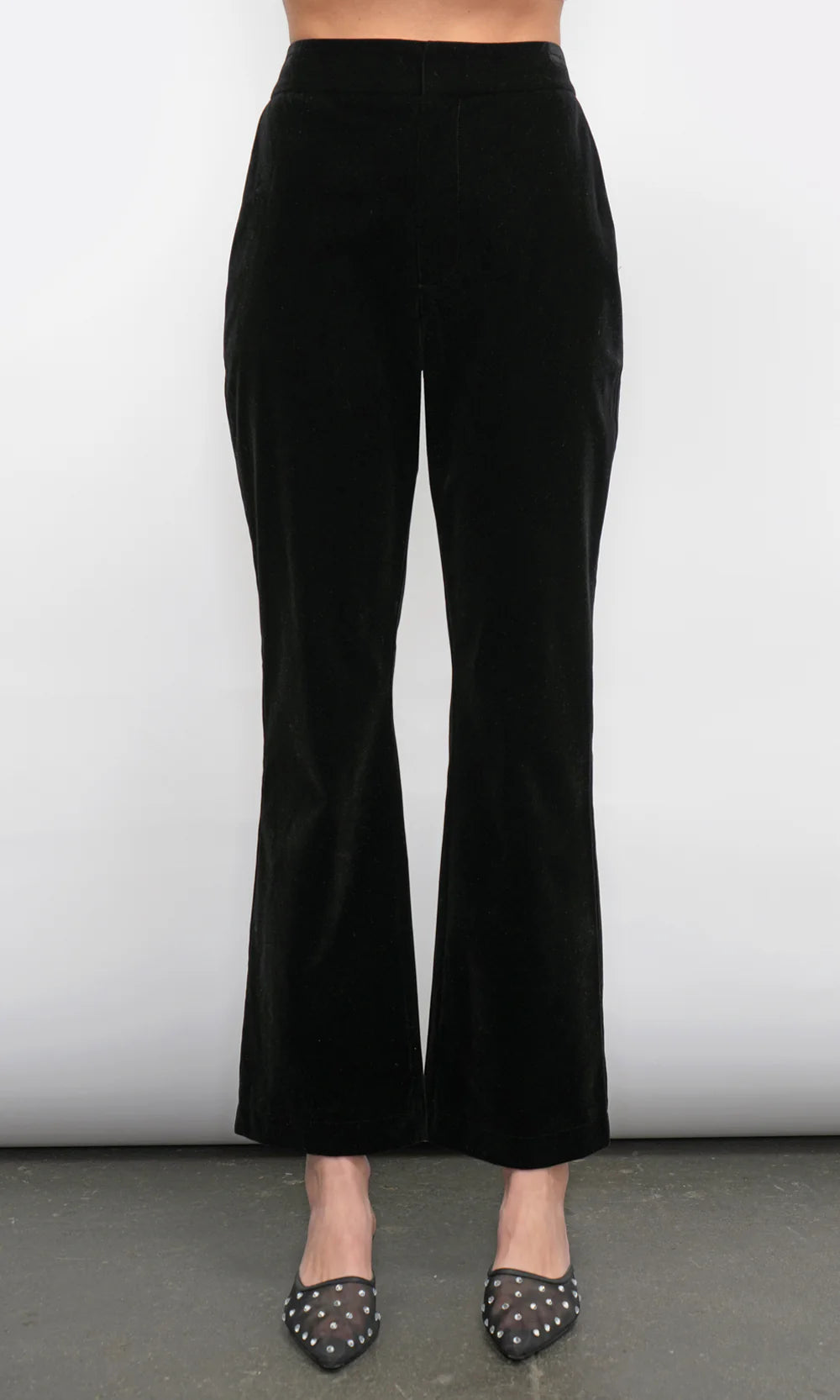 Black flared pants worn by a person on a plain background